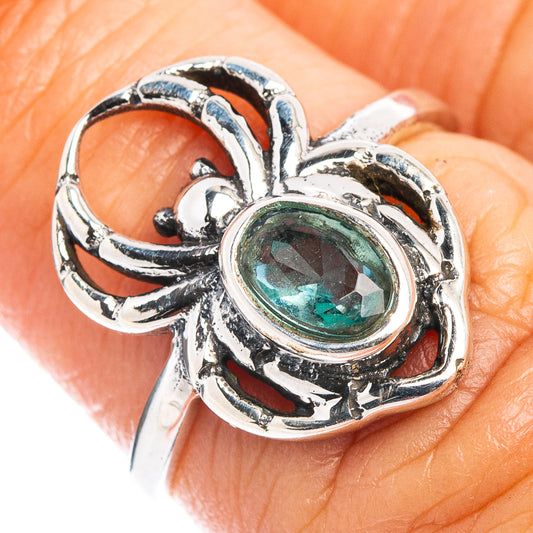 Sterling silver spider ring with oval blue topaz center stone and curved web detail