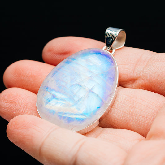 Oval rainbow moonstone pendant in .925 sterling silver bezel, textured bail