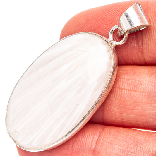Scolecite pendant close-up: oval milky white stone with silver-plated bail