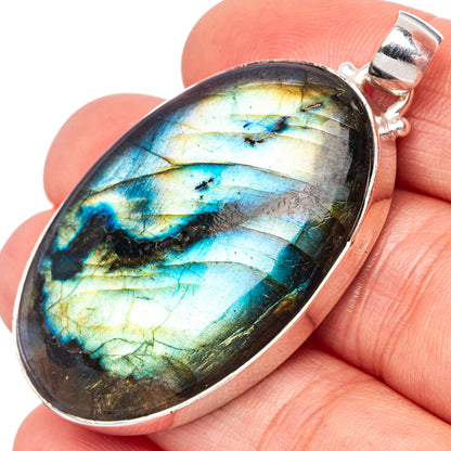 Oval labradorite gemstone pendant in silver bezel with split bail, blue-green flash