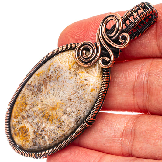 Oxidized copper wire-wrap pendant with mottled oval cabochon and spiral frame details