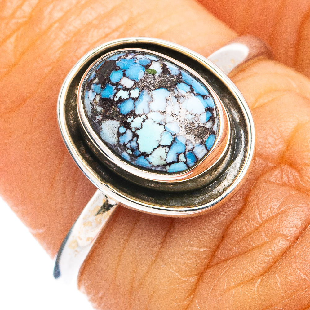 Sterling silver oval turquoise cabochon ring close-up on finger, bezel detail