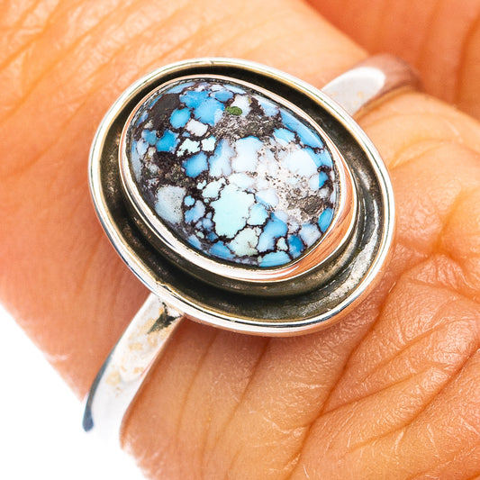 Sterling silver oval turquoise cabochon ring close-up on finger, bezel detail
