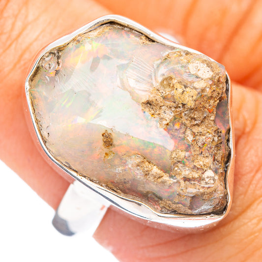 Sterling silver ring with raw opal centerpiece, pear-cut with pale opalescence and gold matrix