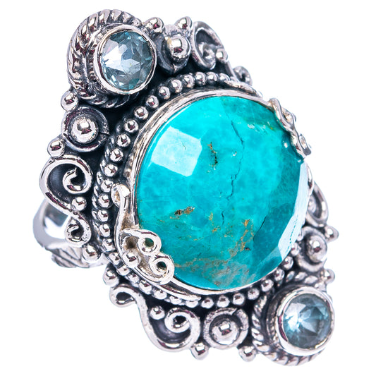 Oval turquoise center ring with ornate .925 sterling silver setting and three blue topaz stones