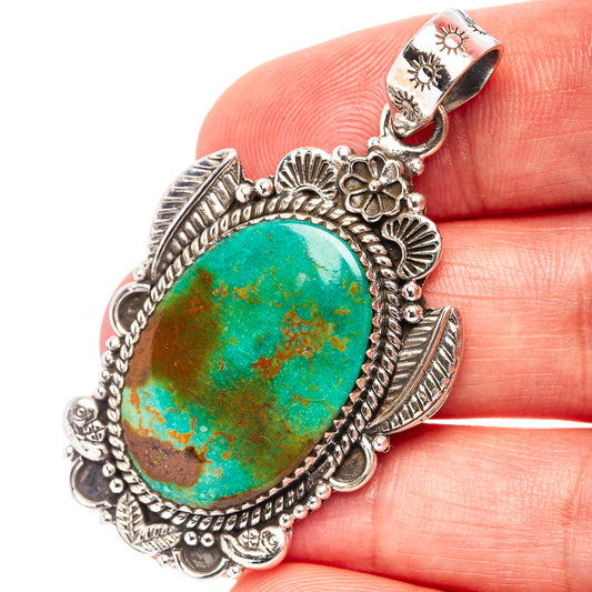 Oval turquoise stone pendant in .925 sterling silver with ornate filigree border
