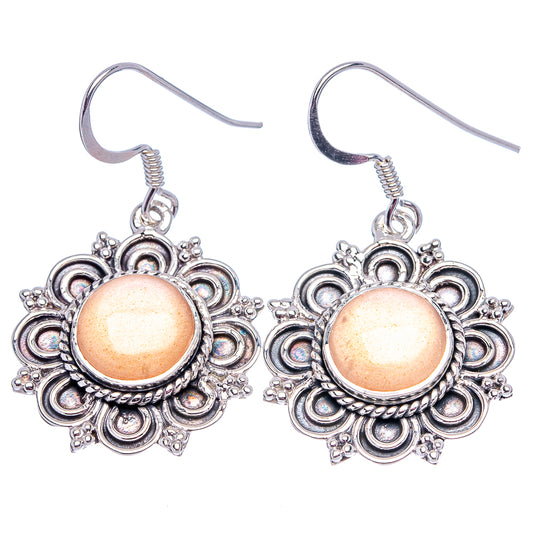 Peach moonstone drop earrings with sterling silver-tone filigree and fishhook backs.