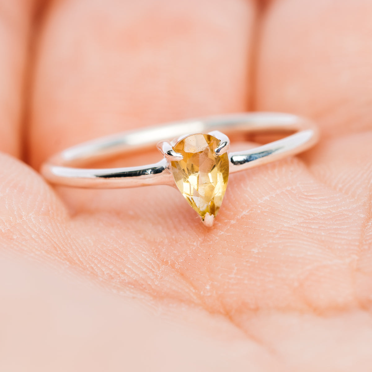 Sterling silver stackable ring with oval yellow gemstone centered in prongs