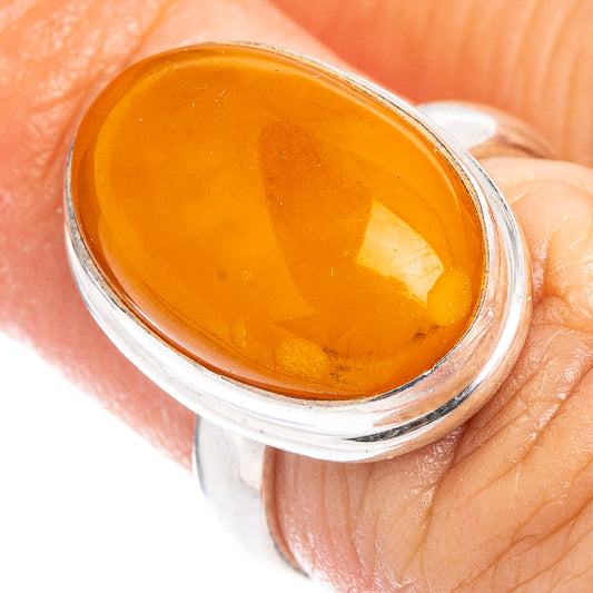 Amber cabochon ring with .925 sterling silver oval setting, close-up on finger