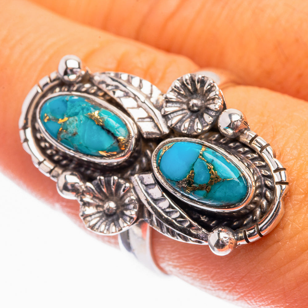 Sterling silver turquoise ring on finger, two oval settings with blue cabochons