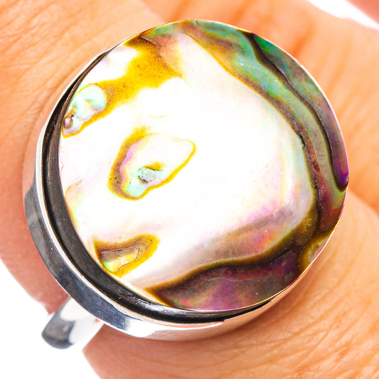 Abalone shell ring with iridescent white, green, and purple stone in silver band
