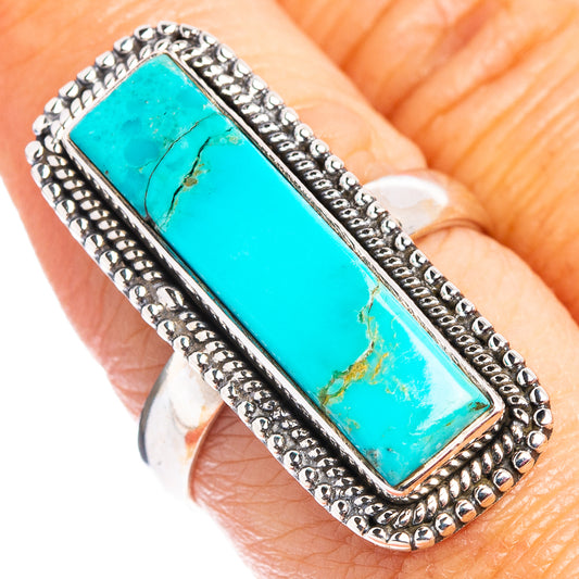 Turquoise rectangle stone ring on finger, ornate silver bead frame