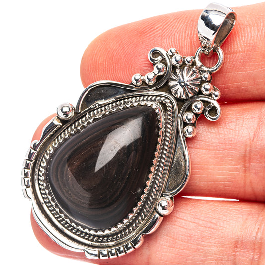 Sterling silver teardrop pendant with dark teardrop stone and decorative bezel