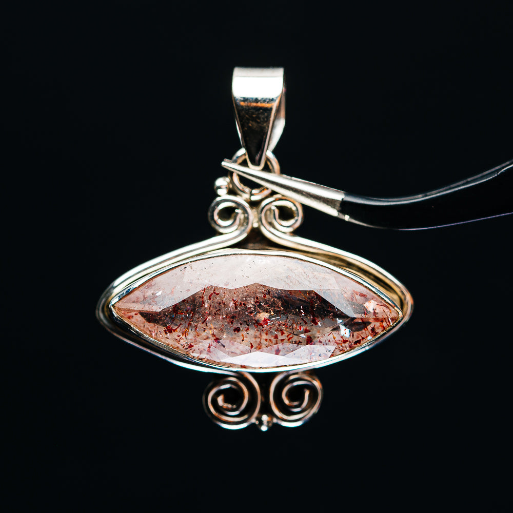 Oval lepidocrocite pendant with faceted red speckled stone in .925 sterling silver frame
