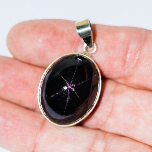 Sterling silver oval star garnet pendant with bezel-set gemstone and bail