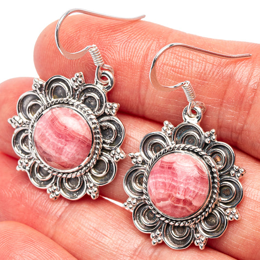 Sterling silver filigree drop earrings with pink round cabochon gemstones and fishhook backs.