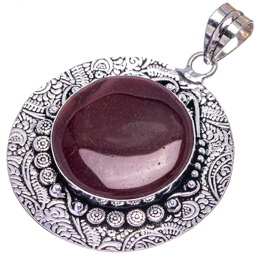 German silver round pendant with maroon cabochon stone, ornate filigree frame and bail