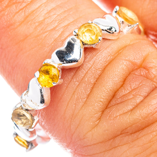 Sterling silver citrine heart ring with prong-set yellow stones on fingertip