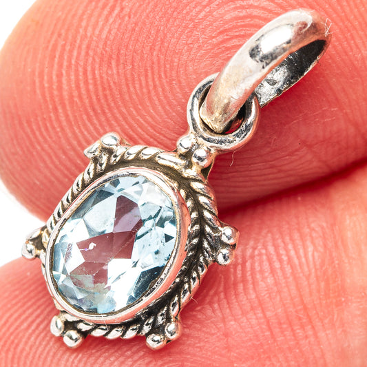 Dainty sterling silver pendant with oval blue topaz gemstone and ornate bezel setting