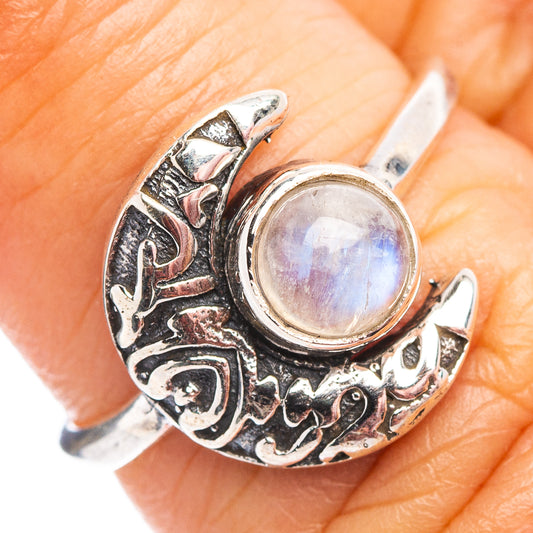Sterling silver moonstone ring on finger, round iridescent cabochon in crescent setting