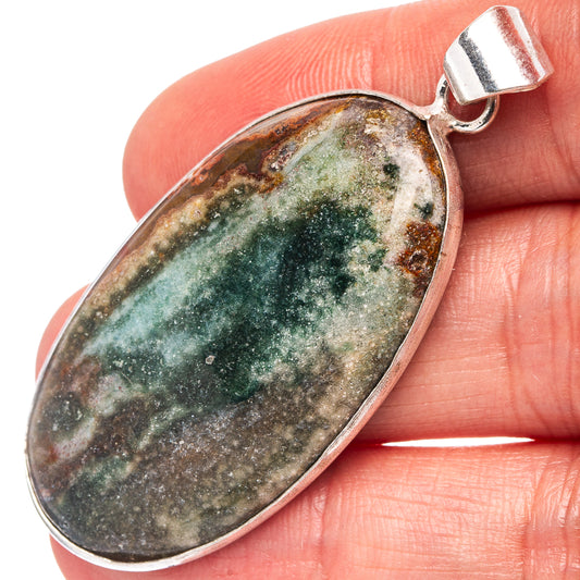Ocean jasper pendant with oval green-gray stone and silver-plated bail, close-up