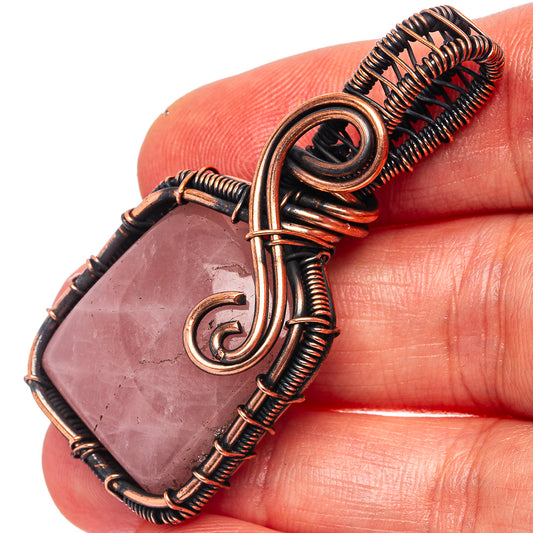 Rose quartz wire-wrapped pendant with oxidized copper frame and spiral wire bail