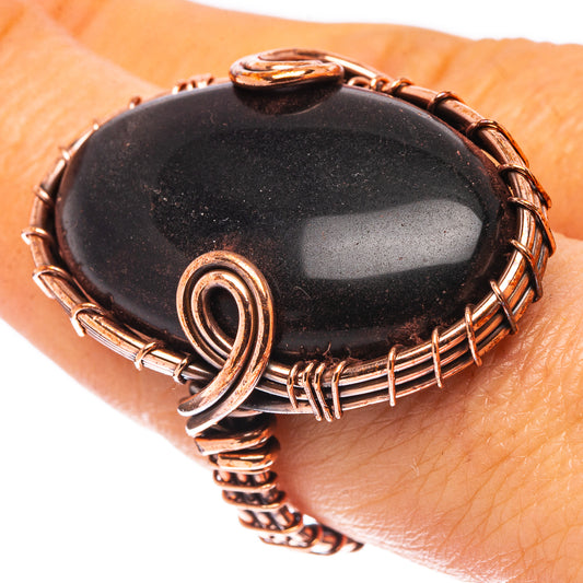 Oval black jet stone wire-wrapped oxidized copper ring on wrist, size 7.5