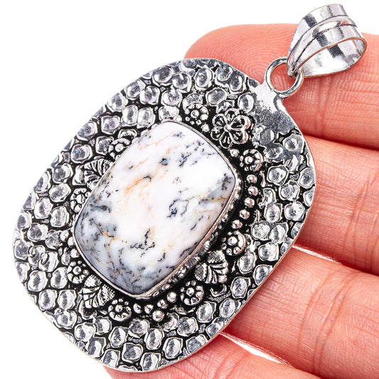 German silver dendritic opal pendant with oval white-blue cabochon and textured border