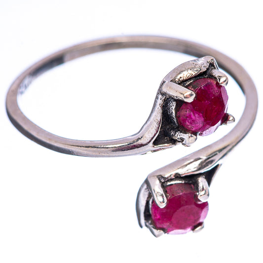 Sterling silver ring with deep red gemstone and smaller side stones in prongs