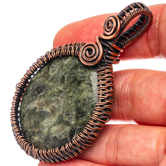 Copper wire-wrapped seraphinite pendant close-up with coiled spiral settings