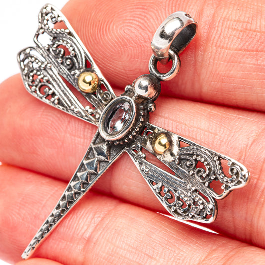 Sterling silver dragonfly pendant with blue topaz-like oval and filigree cross motif