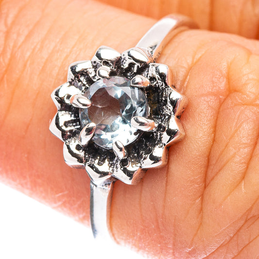 Sterling silver halo ring with round light blue topaz centerpiece, detailed prongs