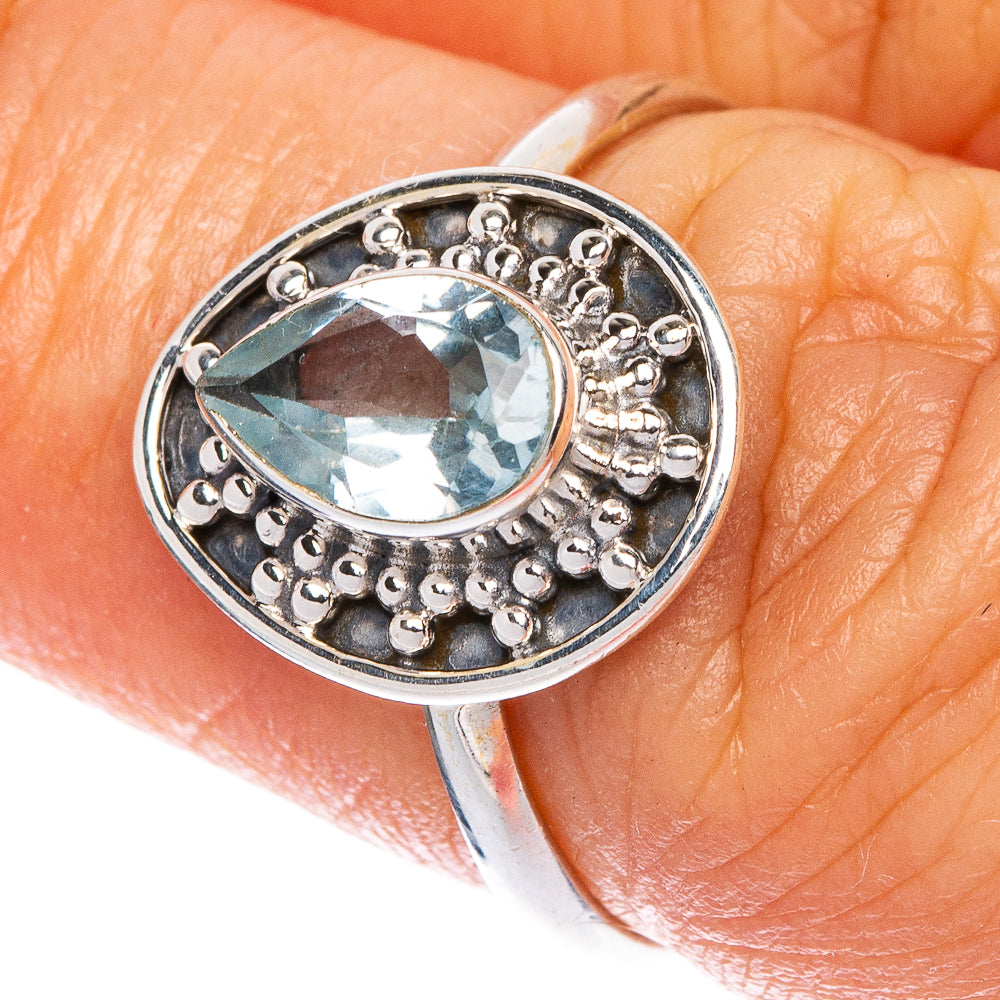 Sterling silver oval blue topaz ring with textured halo and scalloped bezel