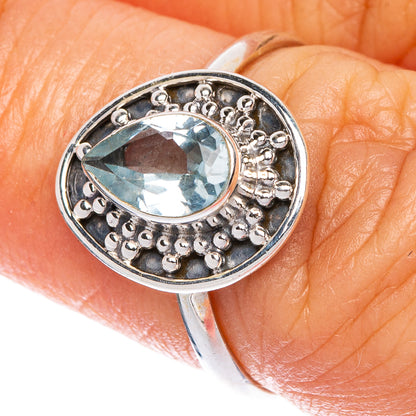 Sterling silver oval blue topaz ring with textured halo and scalloped bezel
