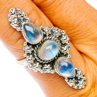 Oval moonstone cabochon ring with three blue iridescent stones in silver setting