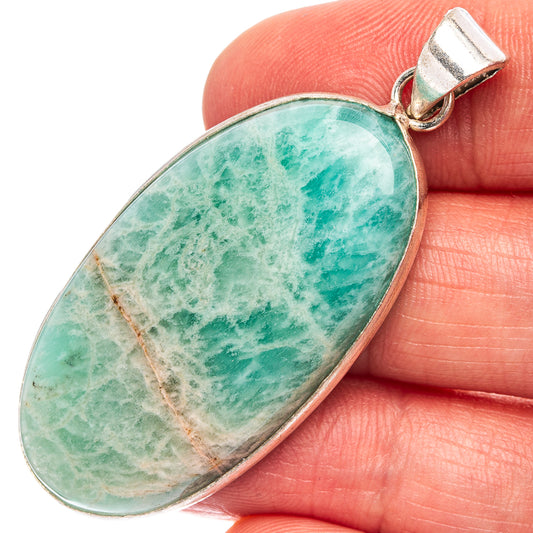 Oval turquoise-green stone pendant with silver bail, close-up on amazonite texture