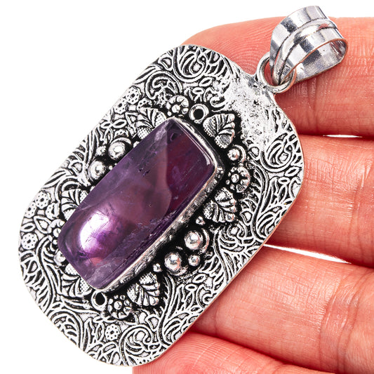 Amethyst rectangle pendant in German silver with ornate scrollwork and purple stone.