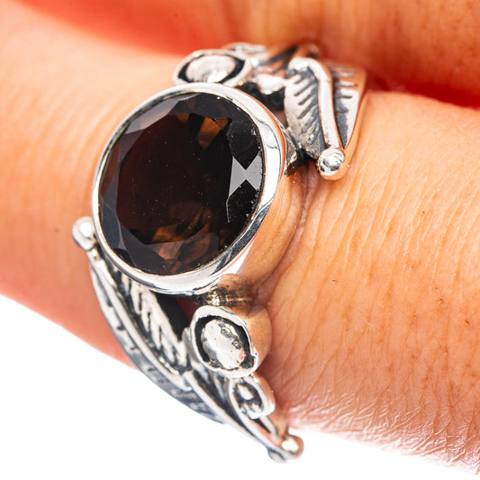 Oval dark gemstone sterling silver ring with ornate bezel and side scrollwork