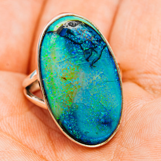 Sterling silver opal ring with oval blue-green stone and dark matrix, side view