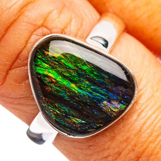 Oval ammolite ring with green-blue iridescent stone in a silver bezel setting