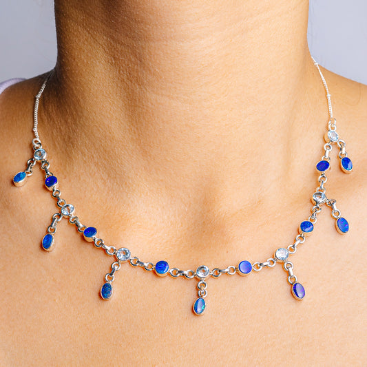 Sterling silver blue topaz necklace with dangling oval gemstones and teardrop charms