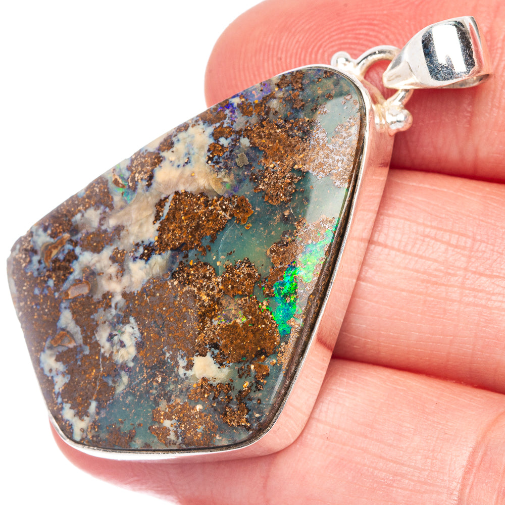 Close-up teardrop boulder opal pendant with multicolor matrix set in 925 silver