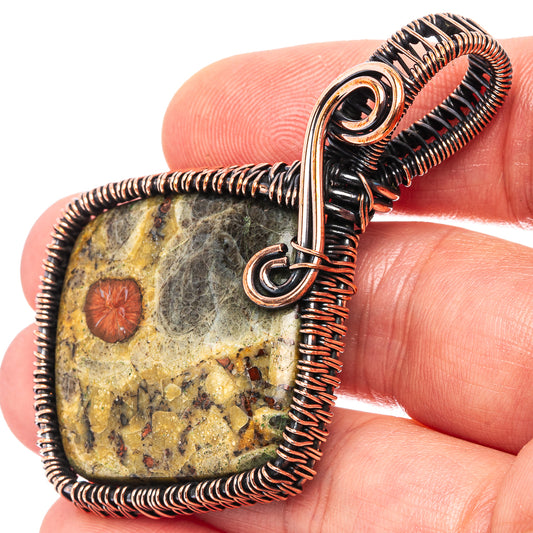 Wire-wrapped oval stone pendant with oxidized copper coils and top ring bail
