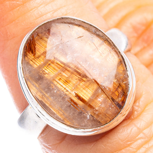 Oval rutilated quartz ring face in sterling silver, close-up of golden needle threads