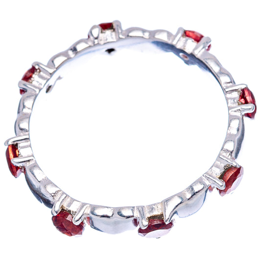 Sterling silver ring with small red garnet stones in prong settings around the band