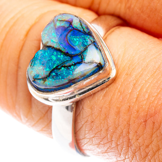 Heart opal sterling silver ring with blue-green iridescent stone on finger