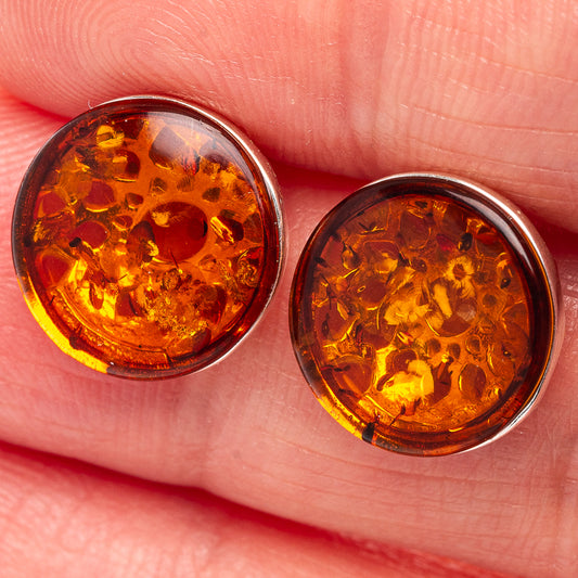 Close-up of amber round stud earrings in .925 sterling silver settings