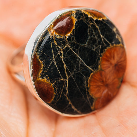 Sterling silver oval inlay ring close-up with dark stone, gold veining, brown spots