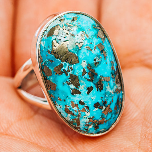 Turquoise oval stone sterling silver ring showing glittery natural matrix pattern