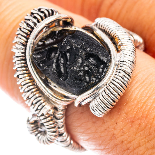 Sterling silver tektite ring with oval dark stone bezel and ribbed rope-style setting